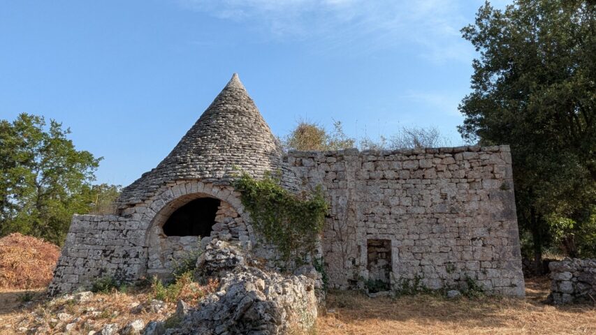 Le trullo et sa lamia. Le trullo et sa lamia en pierre sèche, sous un ciel bleu